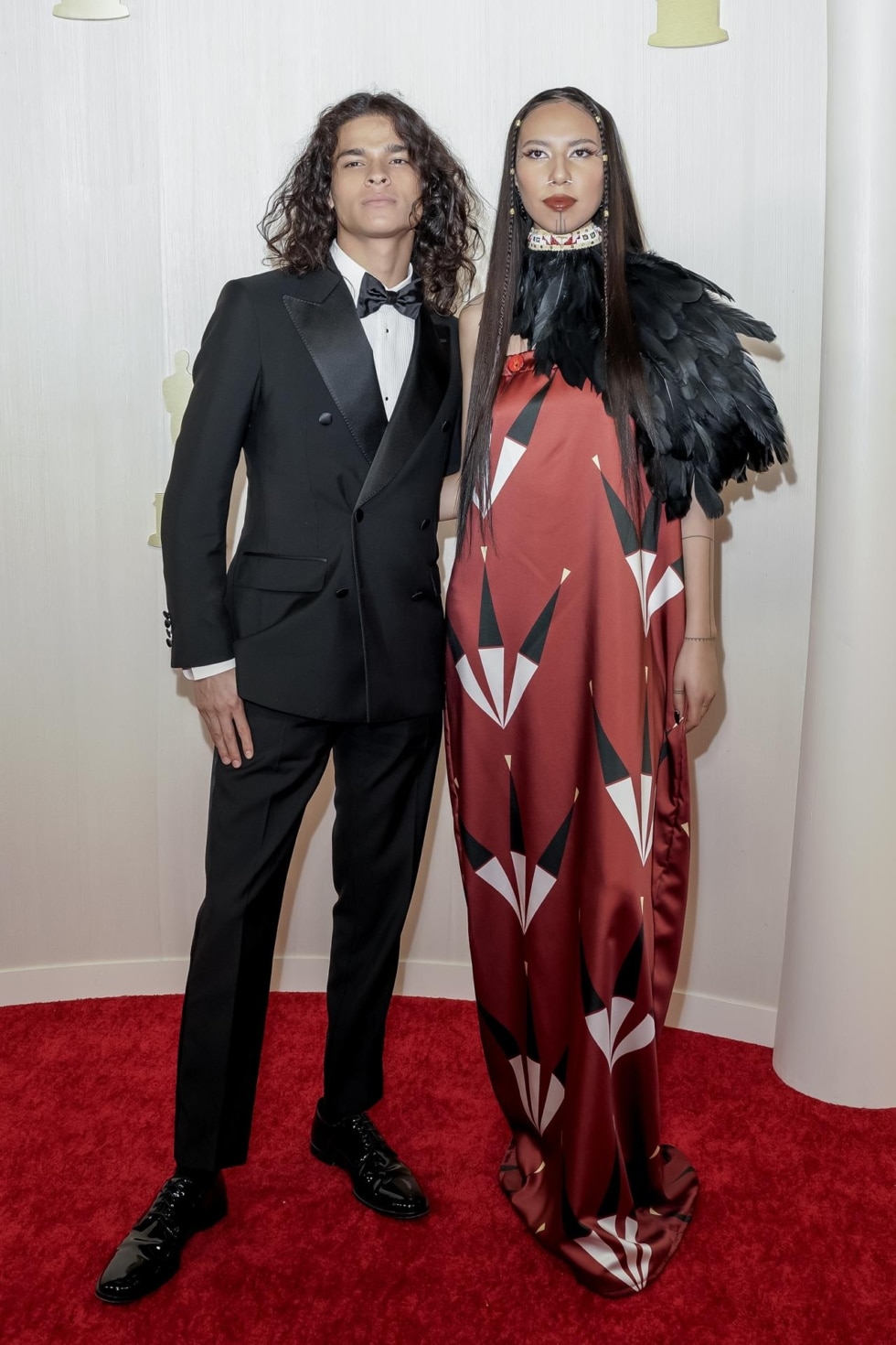 El actor D'Pharaoh Woon-A-Tai y la modelo y activista Quannah Chasinghorse, con un look con el que homenajea su cultura indígena americana, en la alfombra roja de los Oscar.