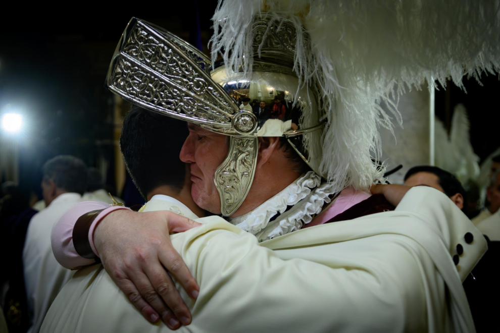 Un 'Armao' de la Hermandad de La Macarena abraza a un nazareno en la Basílica poco después de saber que no podrán hacer la estación de penitencia de la Madrugá del Jueves Santo por la amenaza de lluvia.