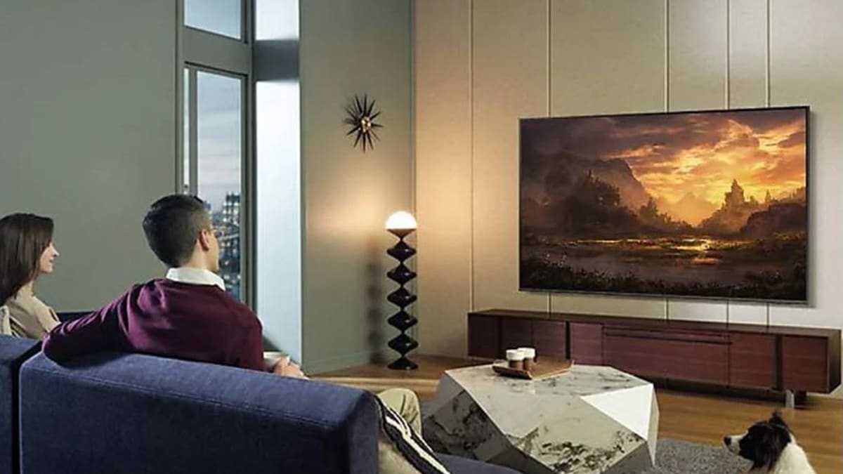 Un hombre y una mujer sentados frente a una smart TV samsung qled