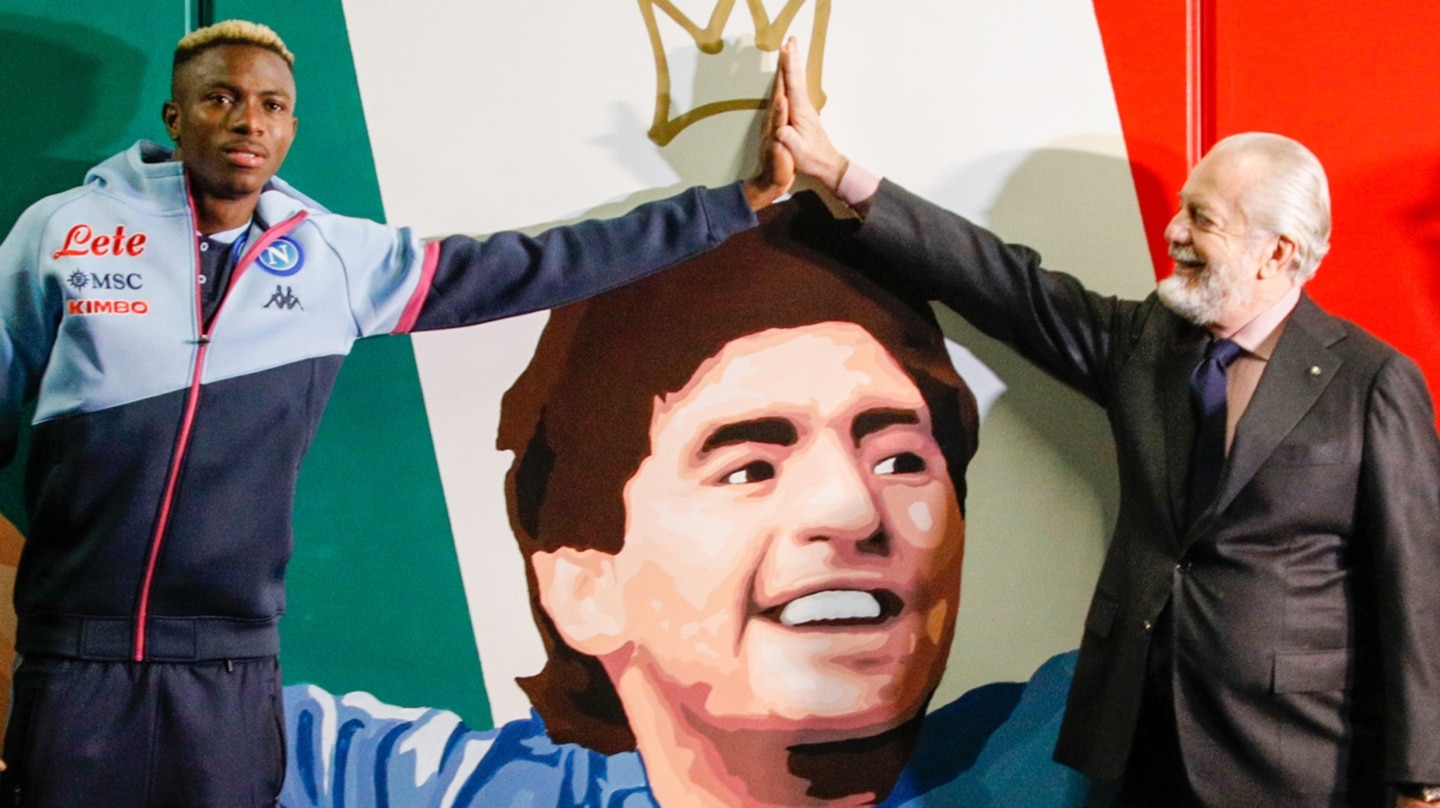 El delantero del Nápoles Victor Osimhen (I) y el presidente Aurelio De Laurentiis en un mural dedicado a Maradona