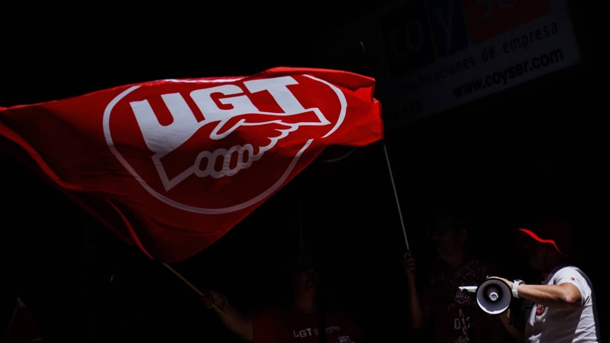 Una persona ondea una bandera de UGT durante una huelga convocada por el sector de contact center, en Madrid.