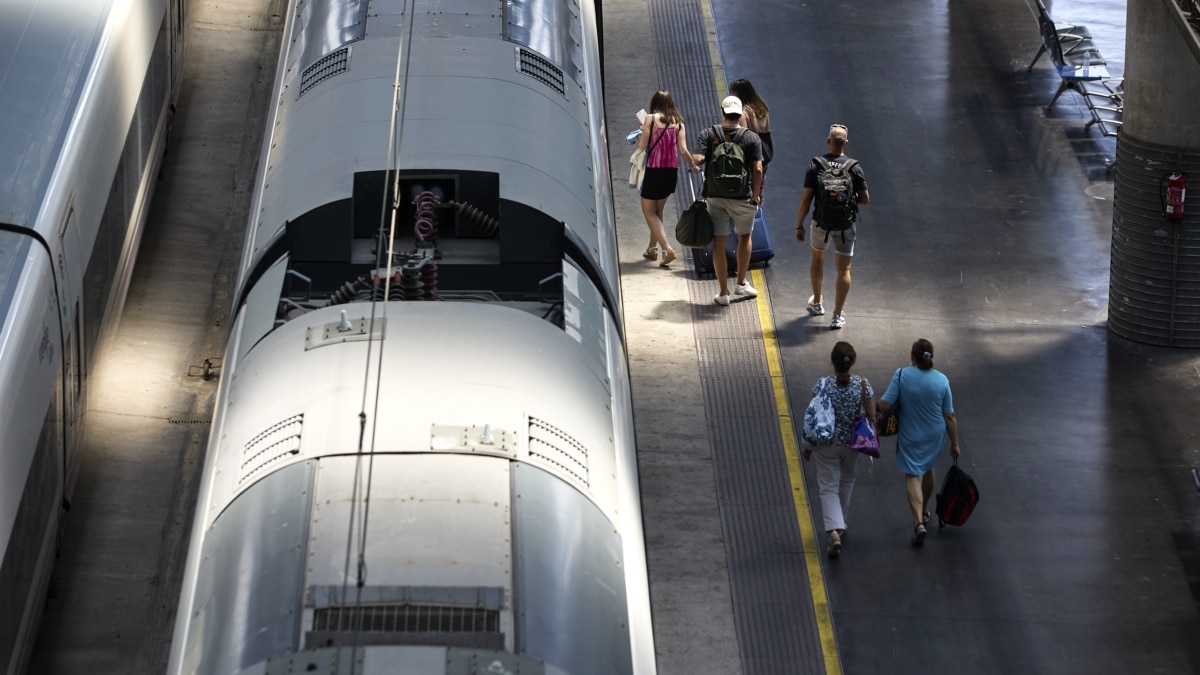 Varias personas caminan por un andén en la estación de Ave Madrid - Puerta de Atocha