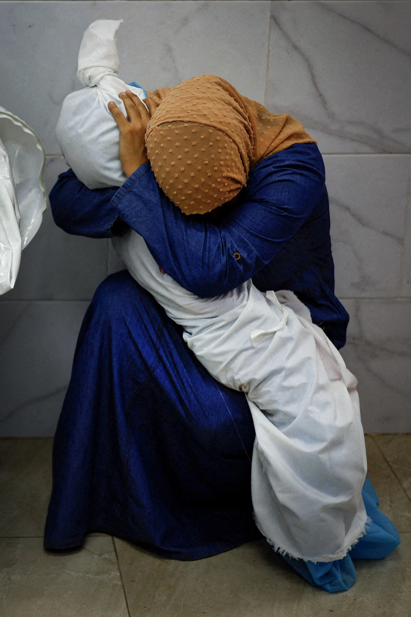 Inas Abu Maamar abraza el cuerpo de su sobrina Saly en el hospital Nasser de Jan Yunis el pasado 17 de octubre. La imagen tomada por el fotógramo Mohammed Salem ha sido considerada la Foto del Año por el jurado del World Press Photo 2024.