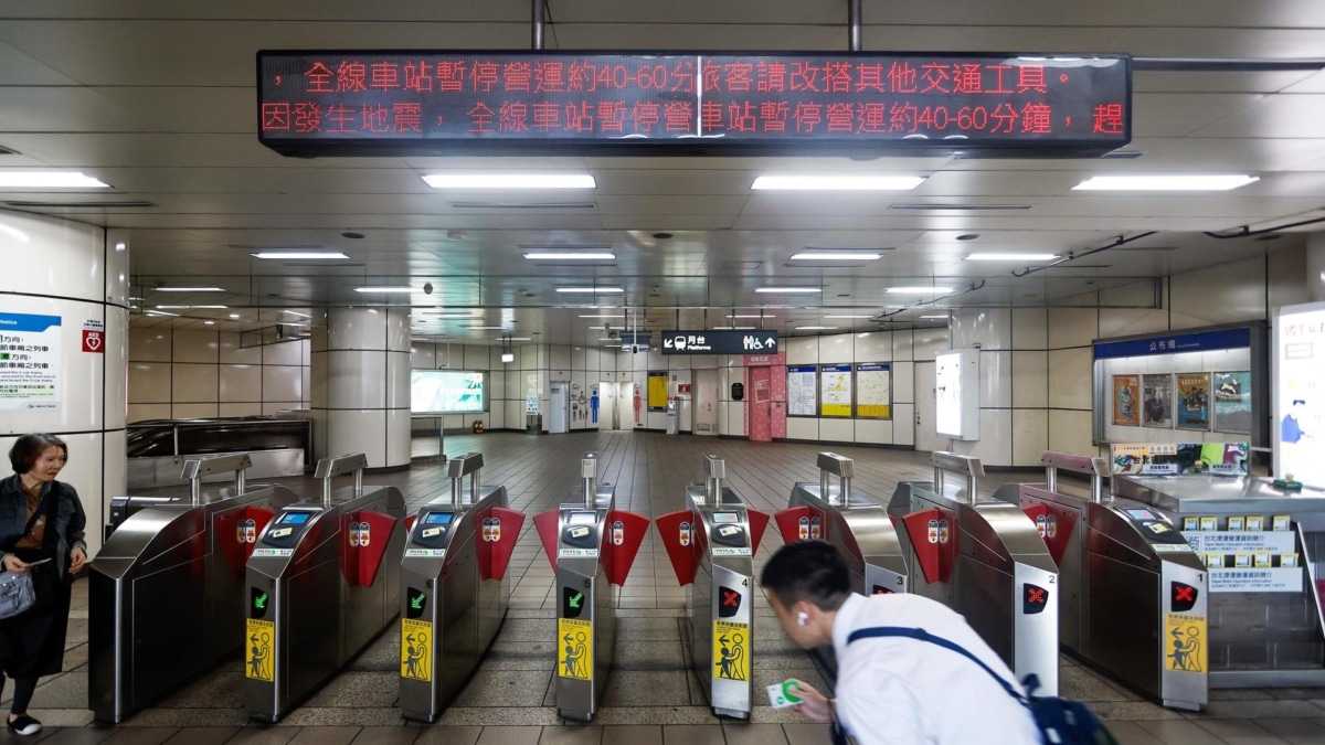 Un hombre camina en el metro de Taipéi, capital de Taiwán, ante un cárcel que anuncia la suspensión del servicio tras el terremoto