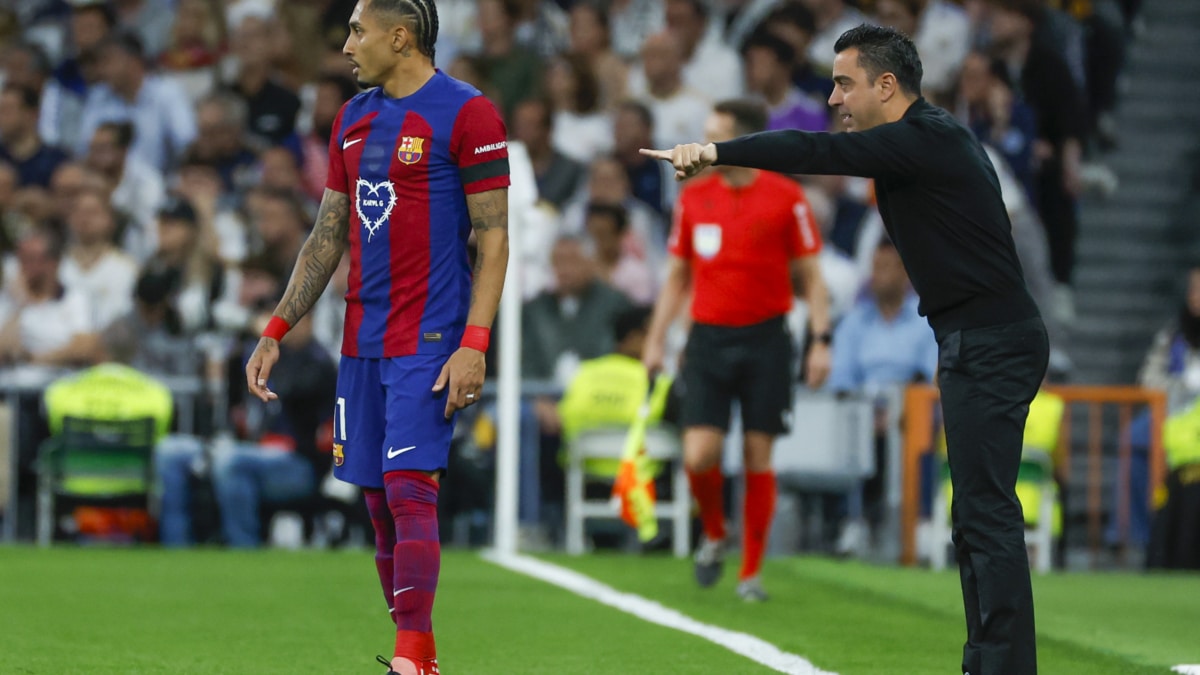 El entrenador del FC Barcelona, Xavi Hernández (d), y del delantero brasileño Raphinha (i) en el Santiago Bernabéu.