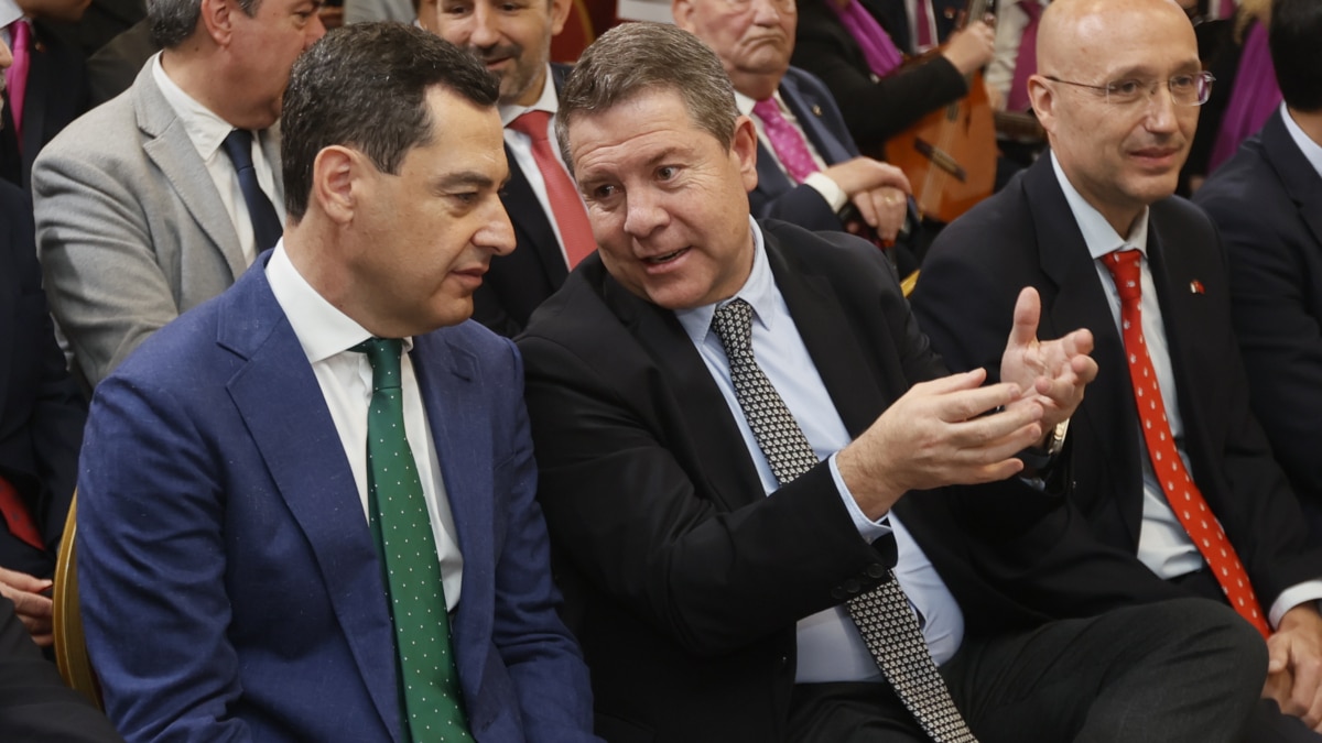 El presidente de la Junta de Andalucía, Juanma Moreno (c), y el presidente de Castilla-La Mancha, Emiliano García-Page (i) durante los actos conmemorativos del 40 aniversario de la Casa de Castilla-La Mancha en Sevilla