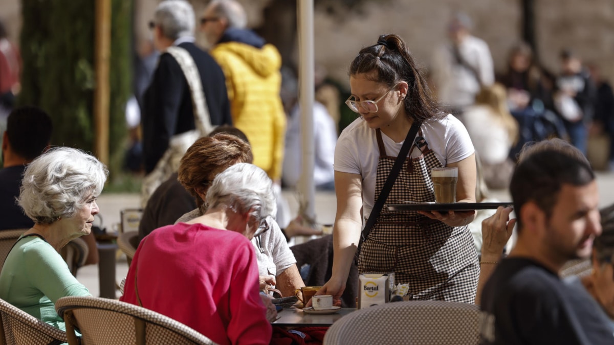 Una camarera atiende una mesa en una terraza en la ciudad de València.