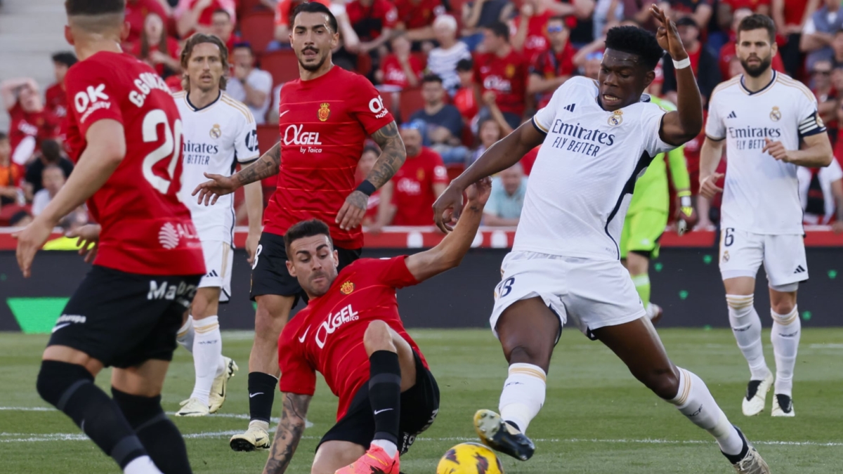 El centrocampista francés del Real Madrid, Aurelien Tchouameni (d), disputa el balón ante el centrocampista del Mallorca, Dani Rodríguez