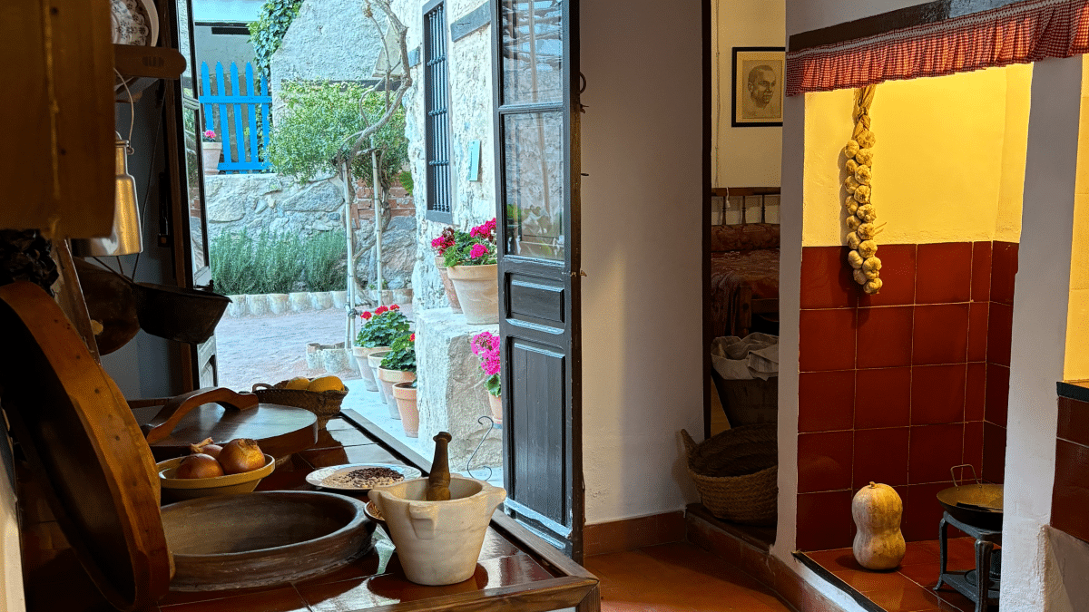 Vista de la cocina con las cebollas y utensilios antiguos, así como el patio de la Casa Museo de Miguel Hernández.