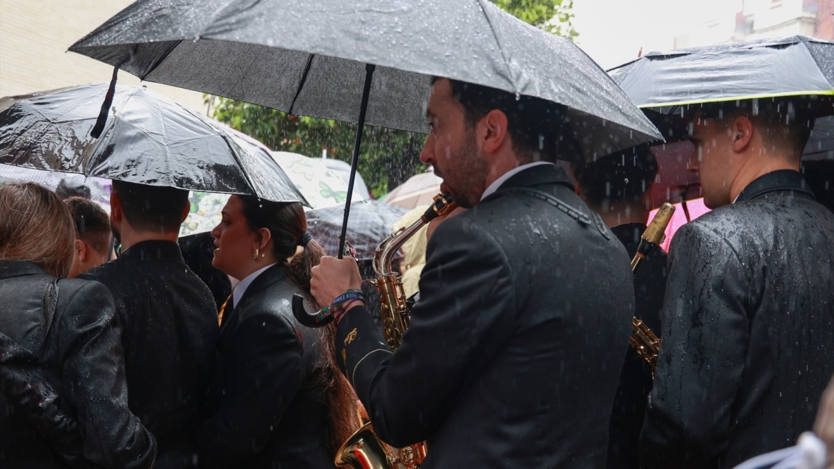 Músicos de la Hermandad del Cautivo de San Pablo, en Sevilla, tras suspenderse por la lluvia su estación de penitencia