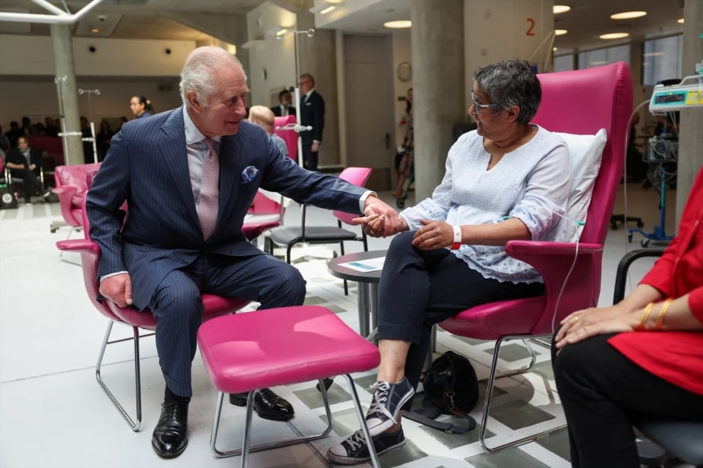 Charles English holds the hand of a cancer patient during treatment. 