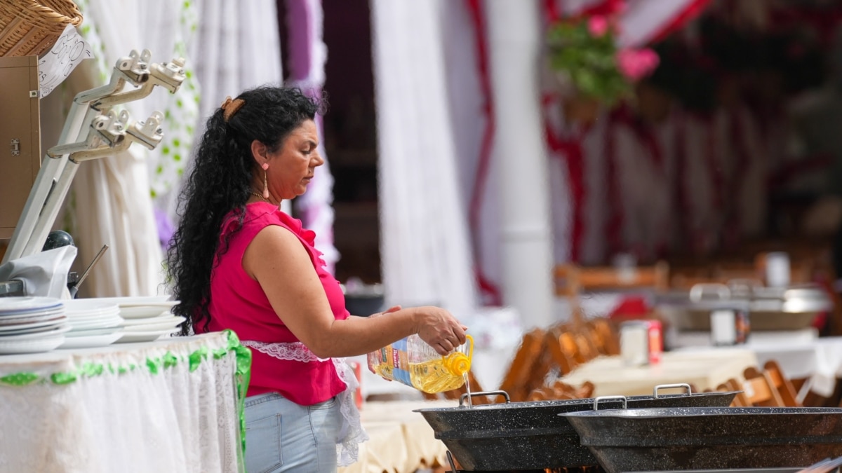 Trabajadora rellena un perol con aceite en una caseta de la feria de Sevilla.