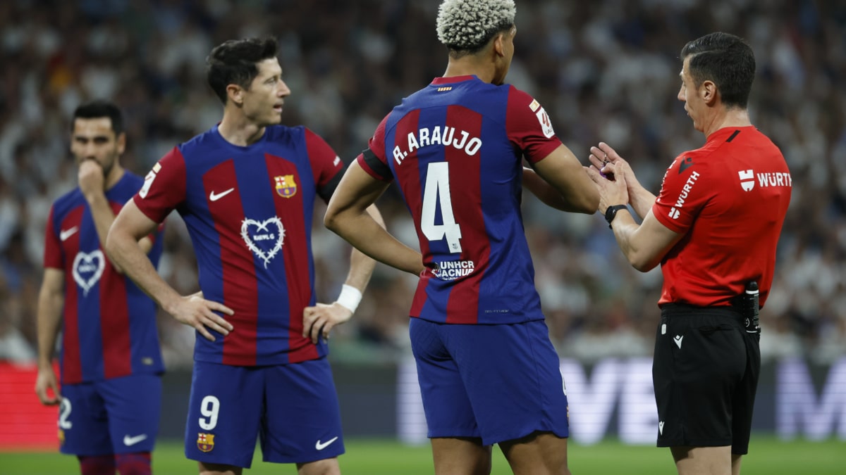 El colegiado César Soto Grado (d) conversa con el defensa uruguayo del FC Barcelona Ronald Araújo (c) durante el clásico del Bernabéu