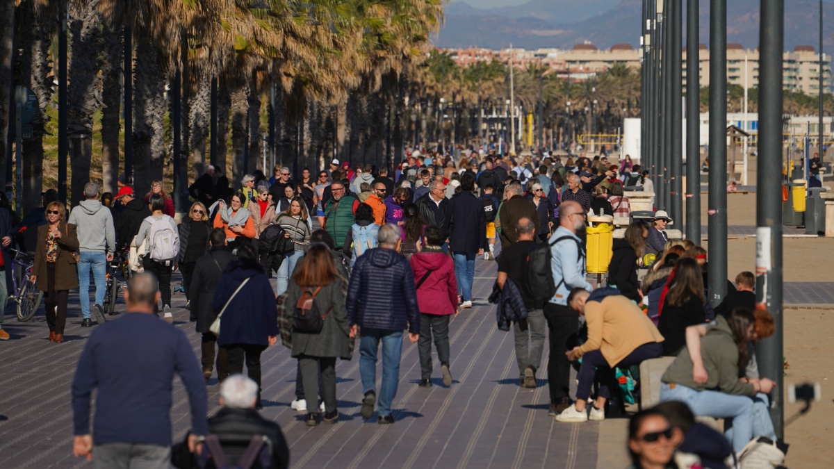 Varias personas pasean por el paseo marítimo, a 25 de diciembre de 2023, en Valencia