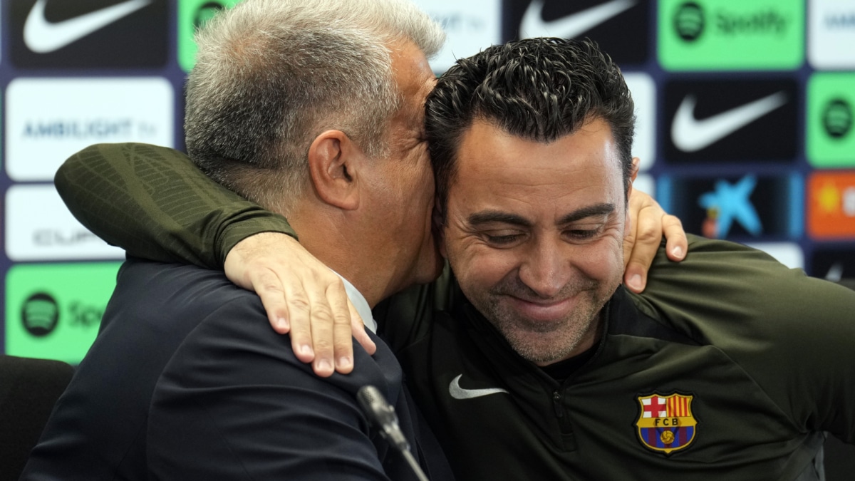 El presidente del FC Barcelona, Joan Laporta, y el técnico Xavi Hernández (d), durante la comparecencia conjunta para confirmar la continuidad del técnico