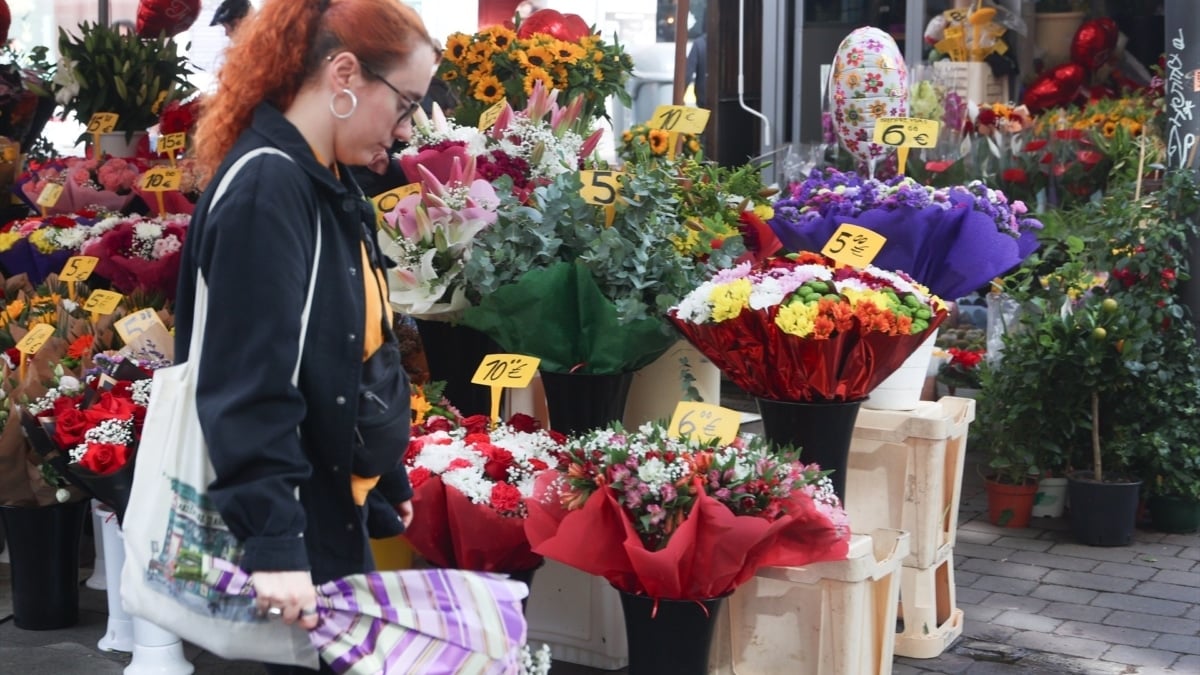 Una mujer compra un ramo de flores en un puesto del Mercado de Flores de Tirso de Molina de Madrid.