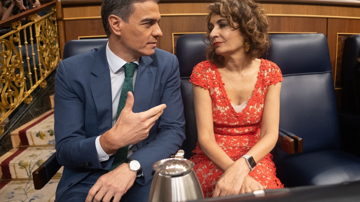 El presidente del Gobierno, Pedro Sánchez, y la vicepresidenta primera y ministra de Hacienda, María Jesús Montero, conversan a su llegada a la sesión extraordinaria en el Congreso de los Diputados.