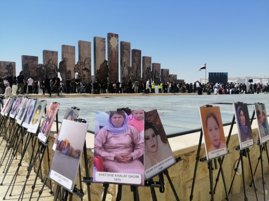 Fotos de víctimas de Dáesh con el memorial al fondo. Sinjar (Irak)