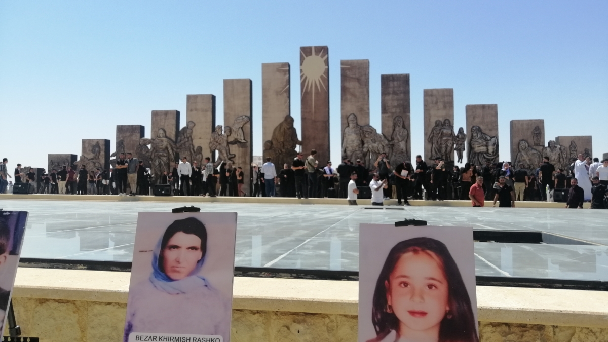 Fotos de víctimas de Dáesh con el memorial al fondo. Sinjar (Irak)