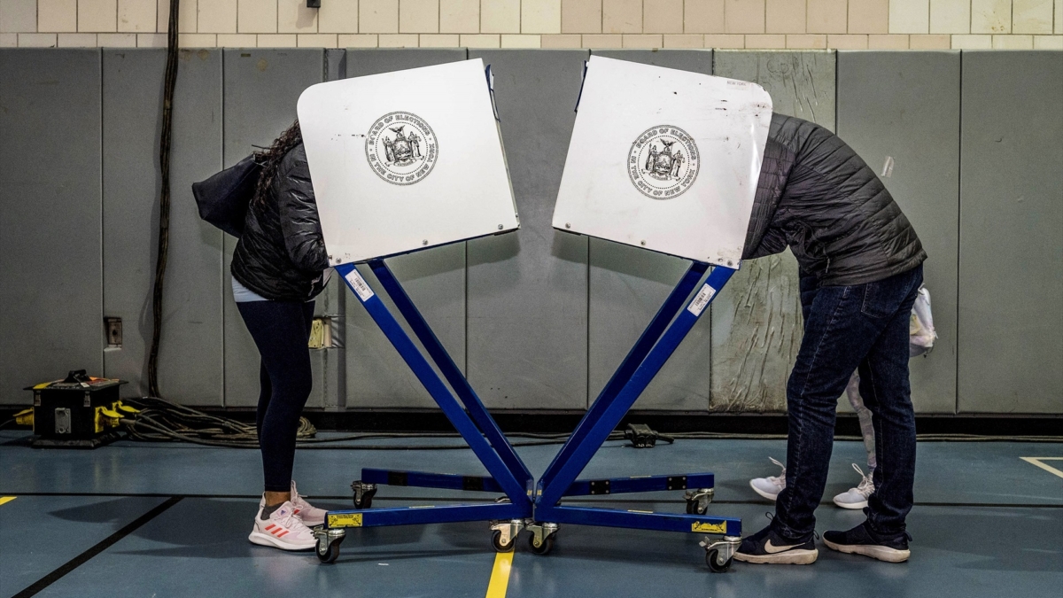Dos personas introducen sus votos en sus papeletas en las elecciones de medio mandato de Estados Unidos, en noviembre de 2022.