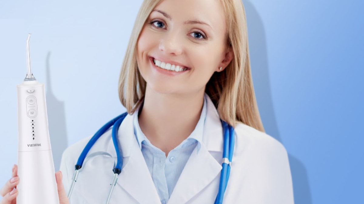 Mujer sujetando el irrigador bucal vimmk