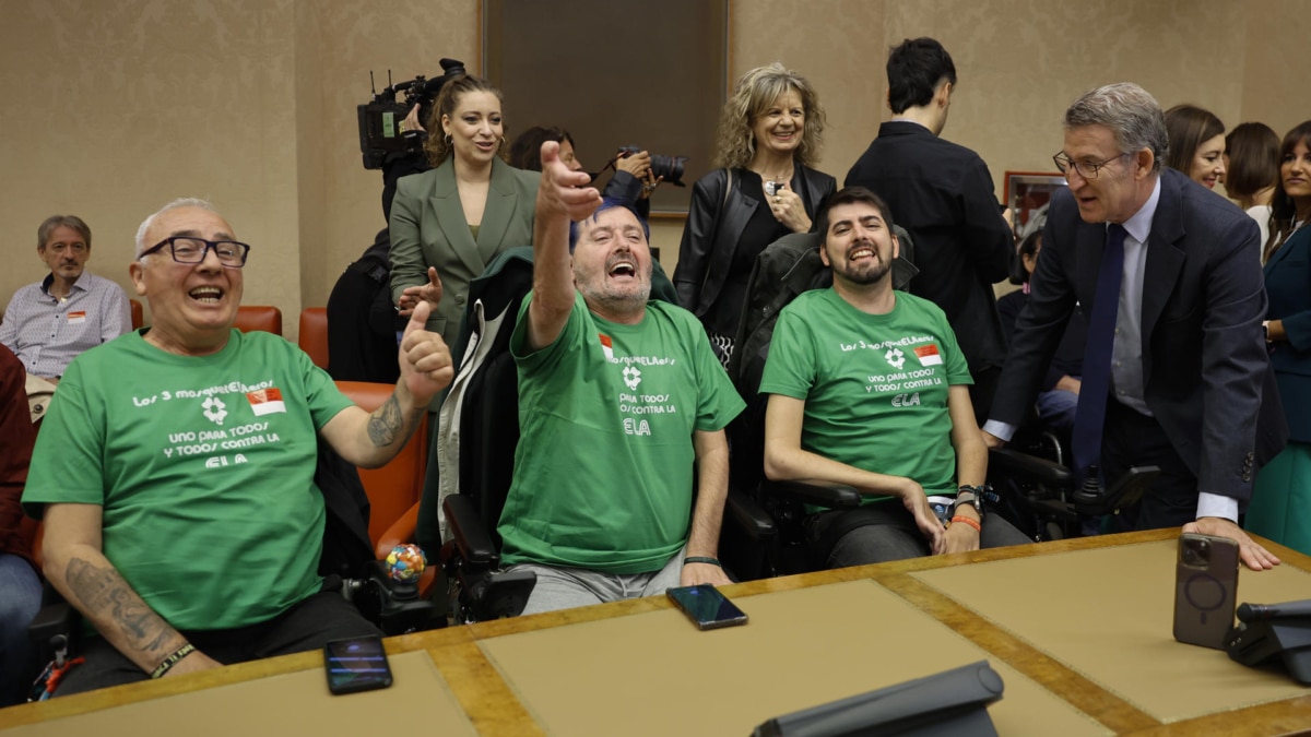 El presidente del PP, Alberto Núñez Feijóo (d), conversa con personas con ELA en el Congreso de los Diputados este jueves
