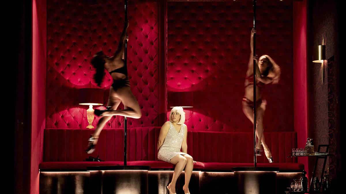Prostíbulo de la escenografía de 'Theodora' que se representa en el Teatro Real con la actriz principal y dos mujeres en barras americanas.