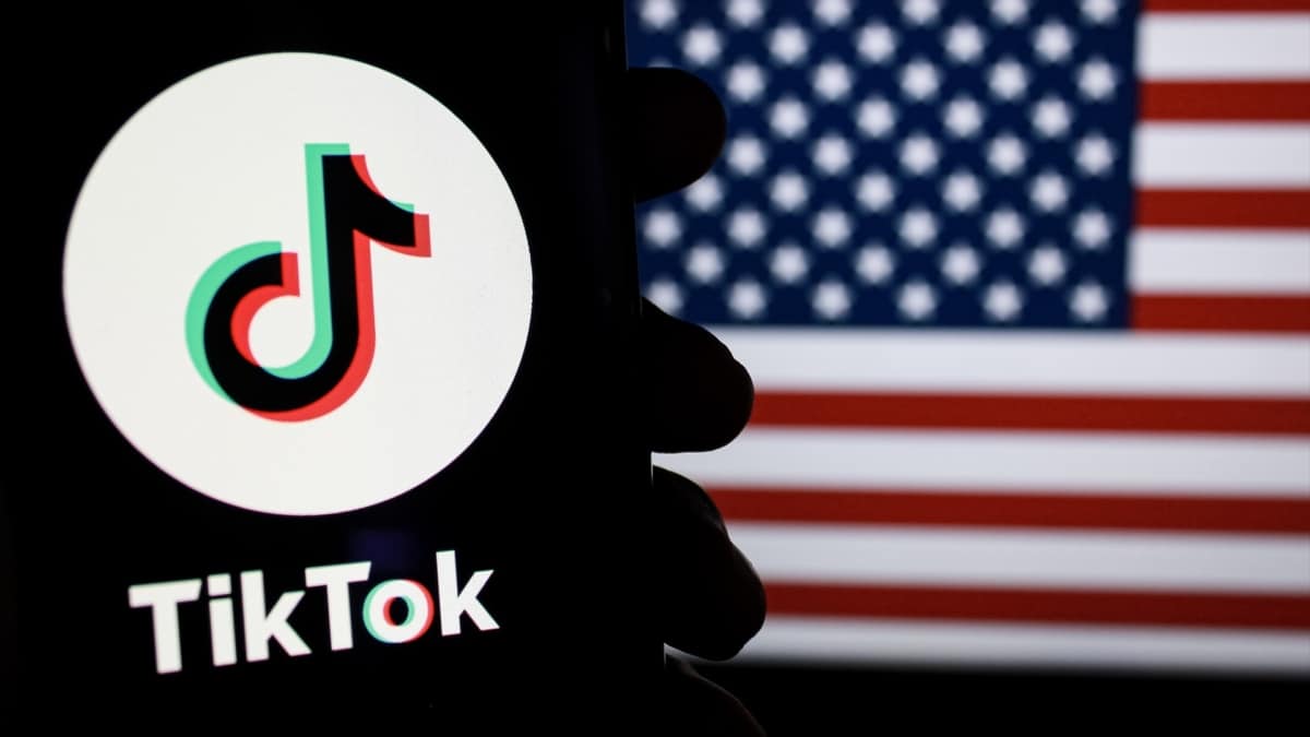 El logo de TikTok con una bandera de Estados Unidos de fondo.