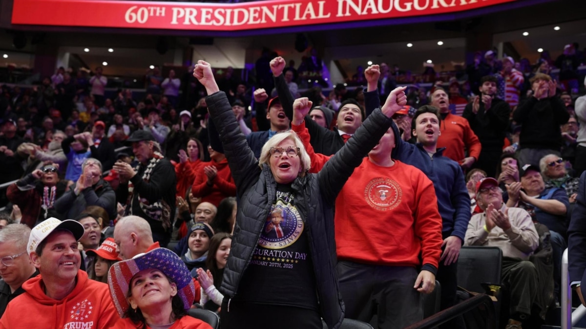 Seguidores de Donald Trump siguen la ceremonia de toma de posesión desde el estadio Capitol One Arena, en Washington DC.