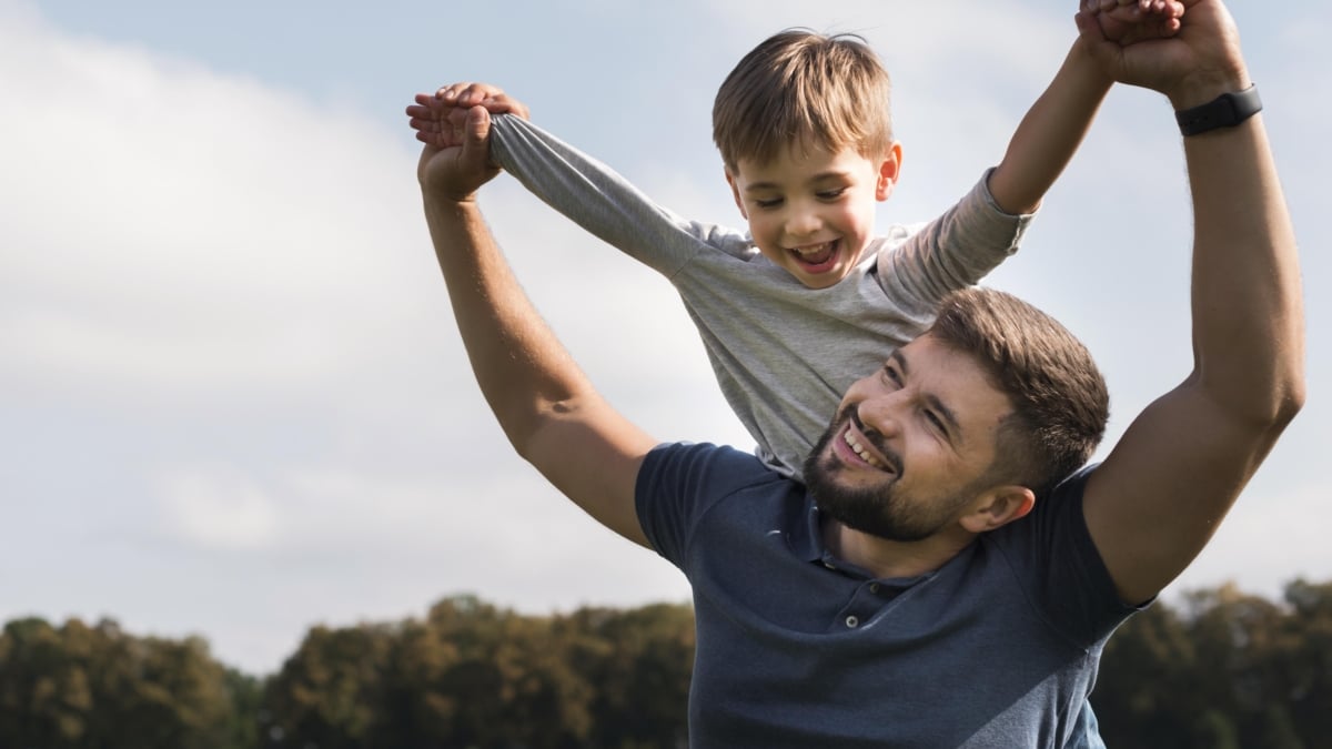 Un padre junto a su hijo cogido a hombros