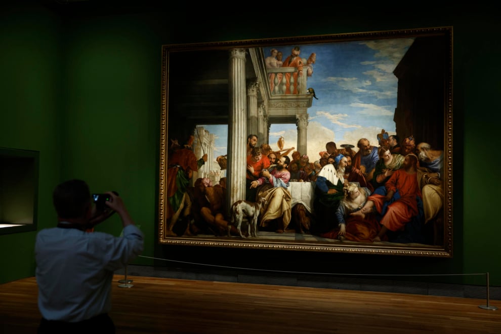 Un hombre fotografía la obra de Paolo Veronese 'Los peregrinos de Emaús', este lunes en el Museo del Prado
