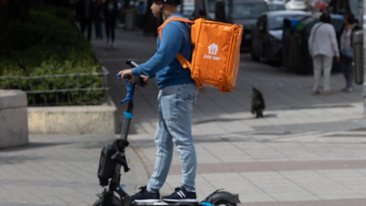 Un hombre montado en un patinete eléctrico en Madrid (España).