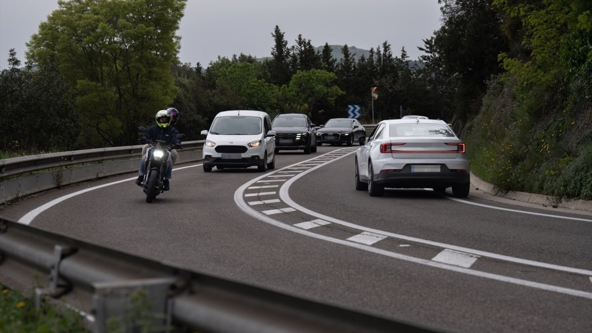 Una carretera por la que circulan una moto y varios coches