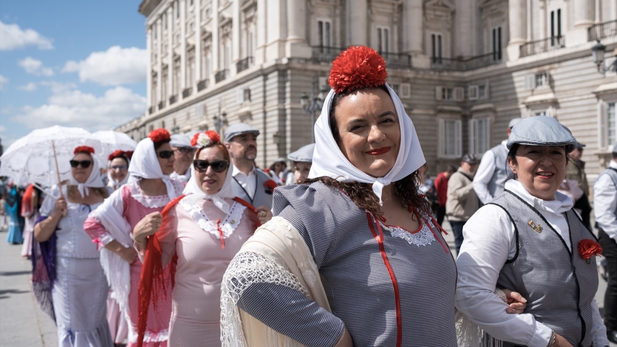 Varias personas durante el pasacalles castizo ‘Bailando por Madrid’ por las Fiestas de San Isidro, en la Plaza Mayor de Madrid.
