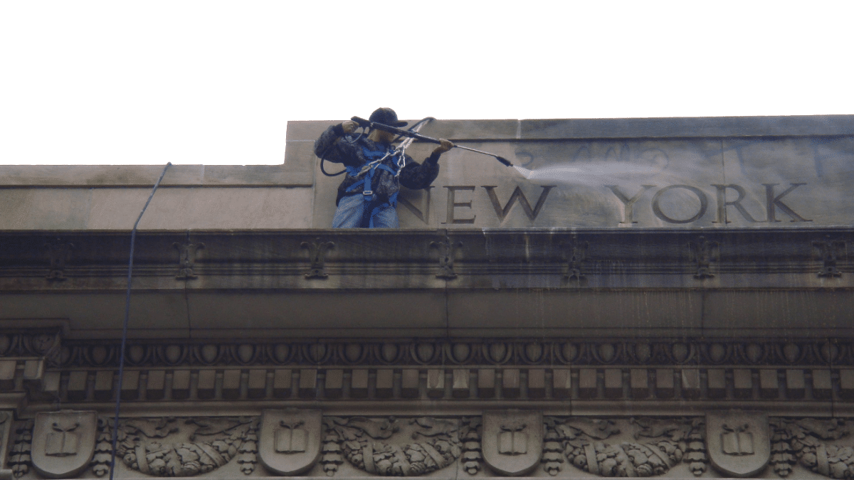 Un operario limpia un grafiti en la fachada de la sucursal de la Biblioteca de Tompkins Square, en el East Village de Manhattan.