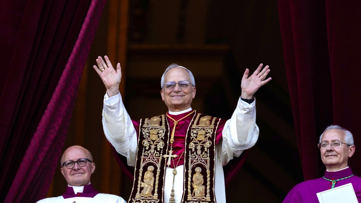 El recién elegido Papa León XIV (C), el estadounidense Robert Prevost, aparece en el balcón