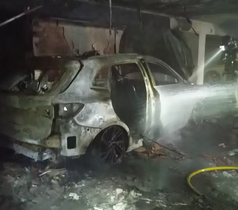 Bomberos trabajan en las labores de extinción de un incendio en un concesionario de coches en Murcia