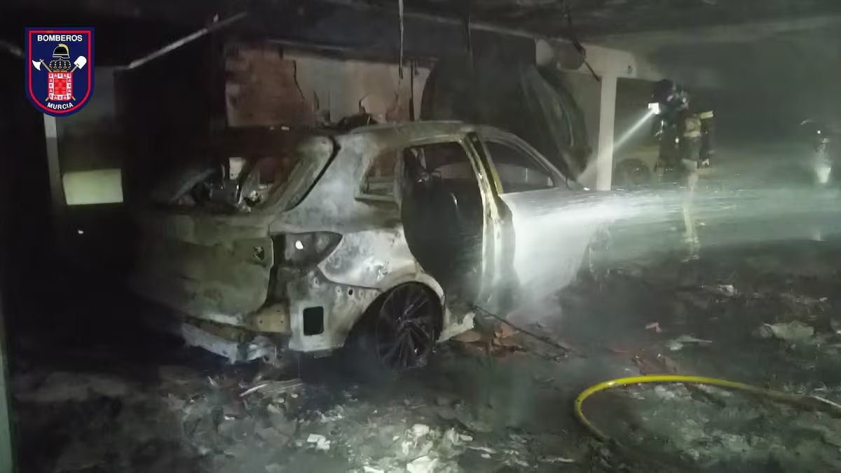 Bomberos trabajan en las labores de extinción de un incendio en un concesionario de coches en Murcia