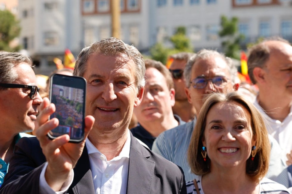 El líder del PP, Alberto Núñez Feijóo, junto a la secretaria general del PP, Cuca Gamarra, muestra una fotografía de la Gran Vía llena de manifestantes.