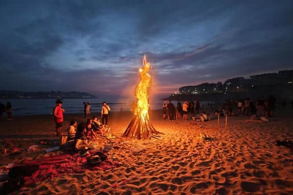 Imagen de una de las hogueras encendidas hoy lunes en la playa coruñesa de Riazor