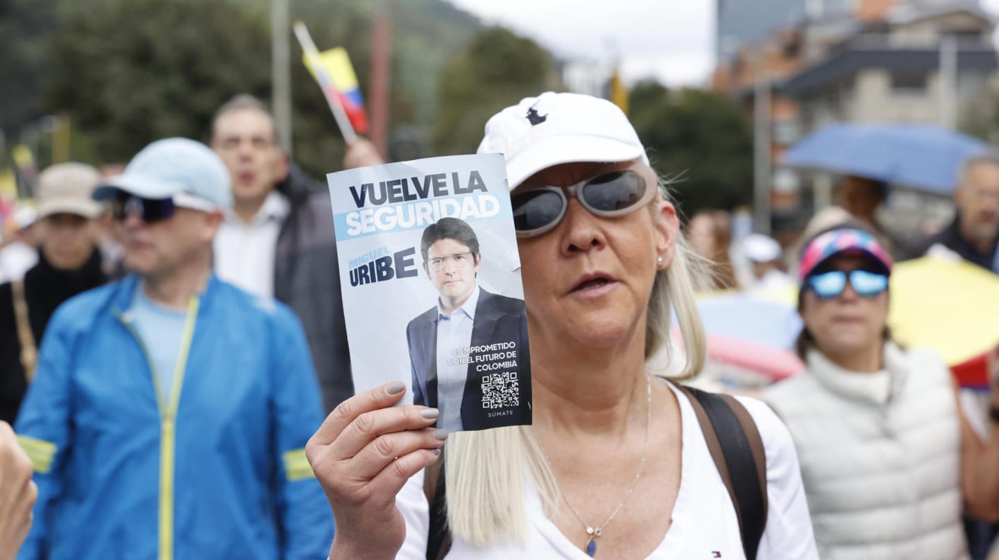 Una mujer sostiene una imagen de Uribe Turbay durante una caminata por la paz en apoyo al senador que acaba de sufrir un atentado en Bogotá.