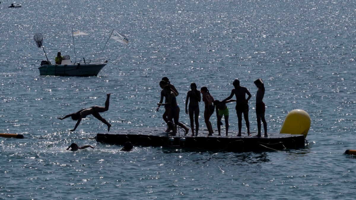 Varias personas se bañan en la playa