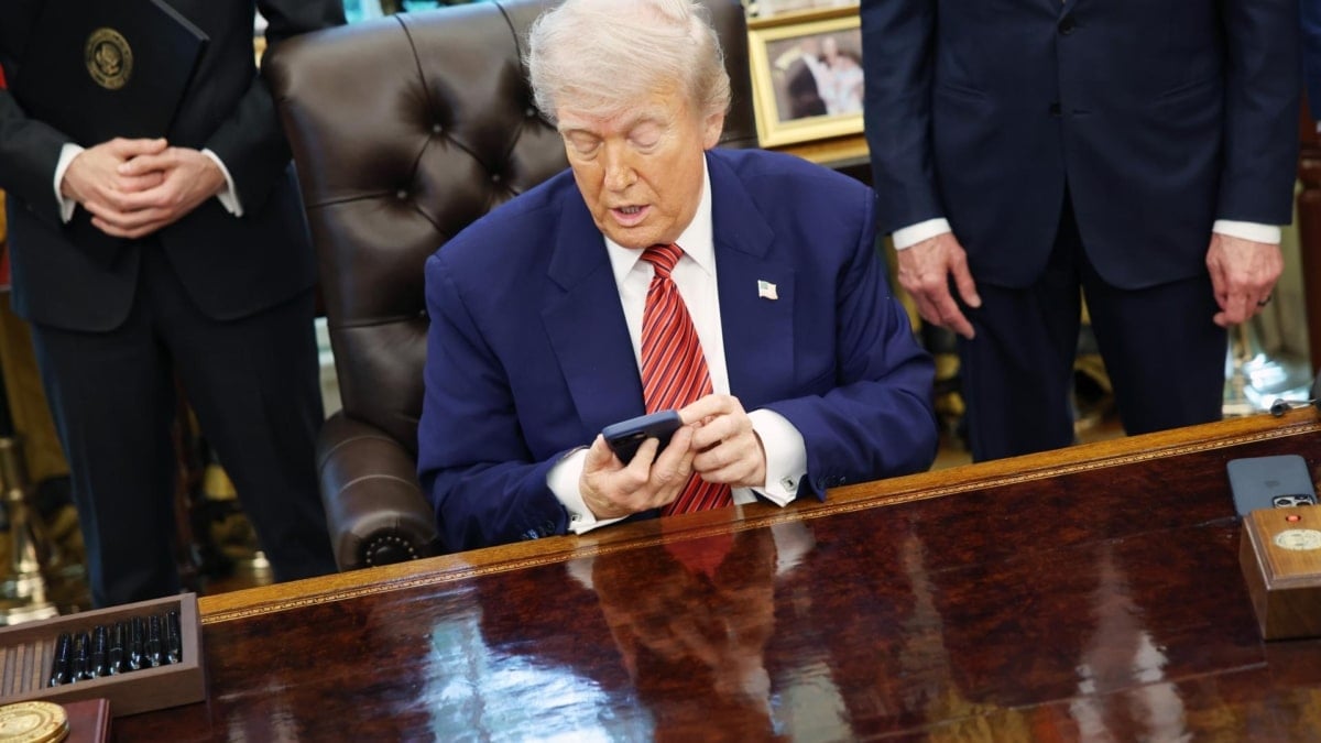 El presidente estadounidense, Donald Trump, consulta su teléfono antes de firmar órdenes ejecutivas en el Despacho Oval el pasado 23 de mayo.