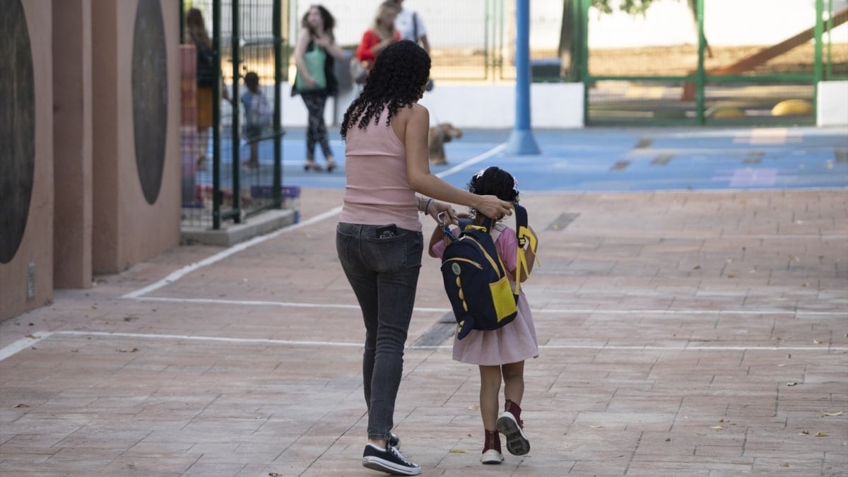 Una madre acompaña a su hija a clase en un colegio de Valencia.