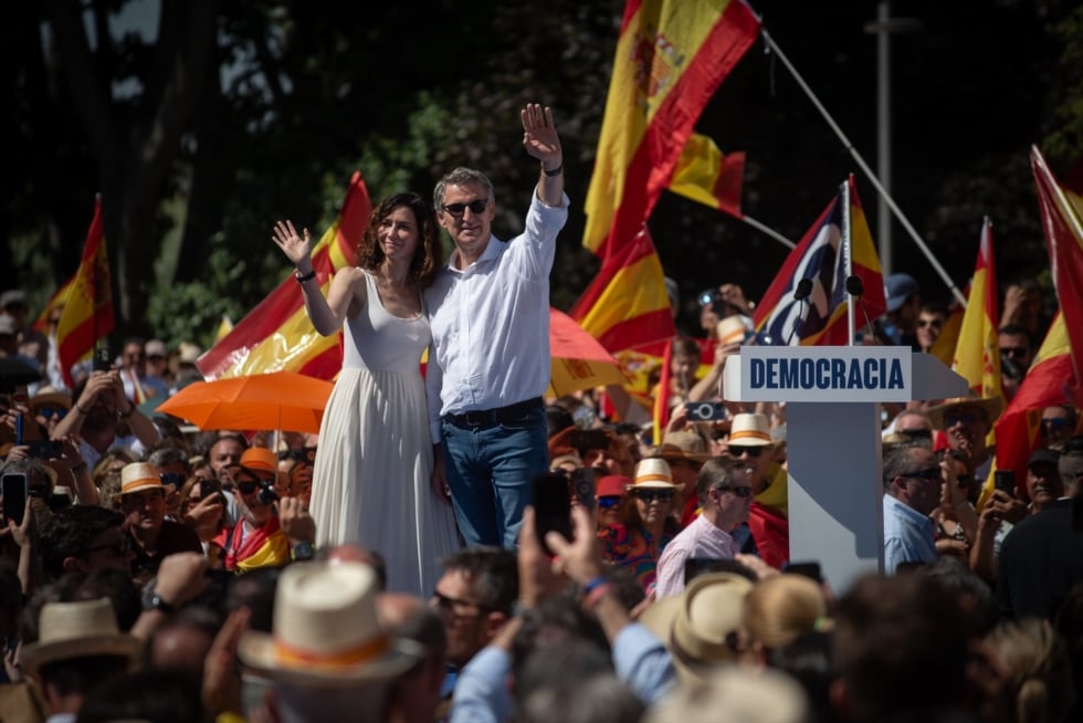 El presidente del Partido Popular, Alberto Núñez Feijóo, y la presidenta de la Comunidad de Madrid, Isabel Díaz Ayuso, saludan al finalizar el acto de Plaza de España.