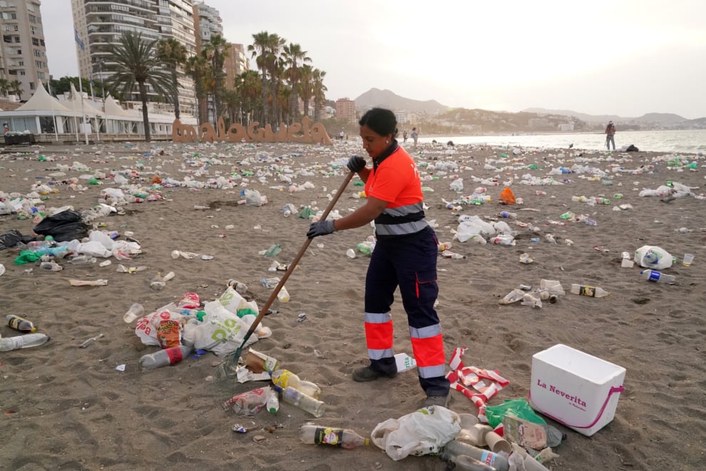Un operario del servicio de limpieza municipal de Málaga recoge restos de basura