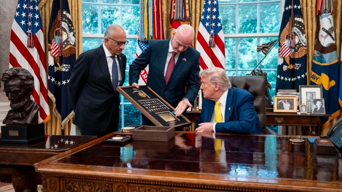 El presidente de la FIFA, Giani Infantino, enseña uons pins del equipo al presidente de EEUU, Donald Trump, este miércoles en el Despacho Oval.