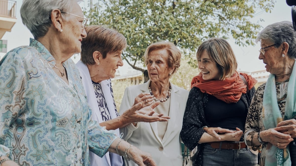 Personas mayores paseando y charlando con alguien más joven