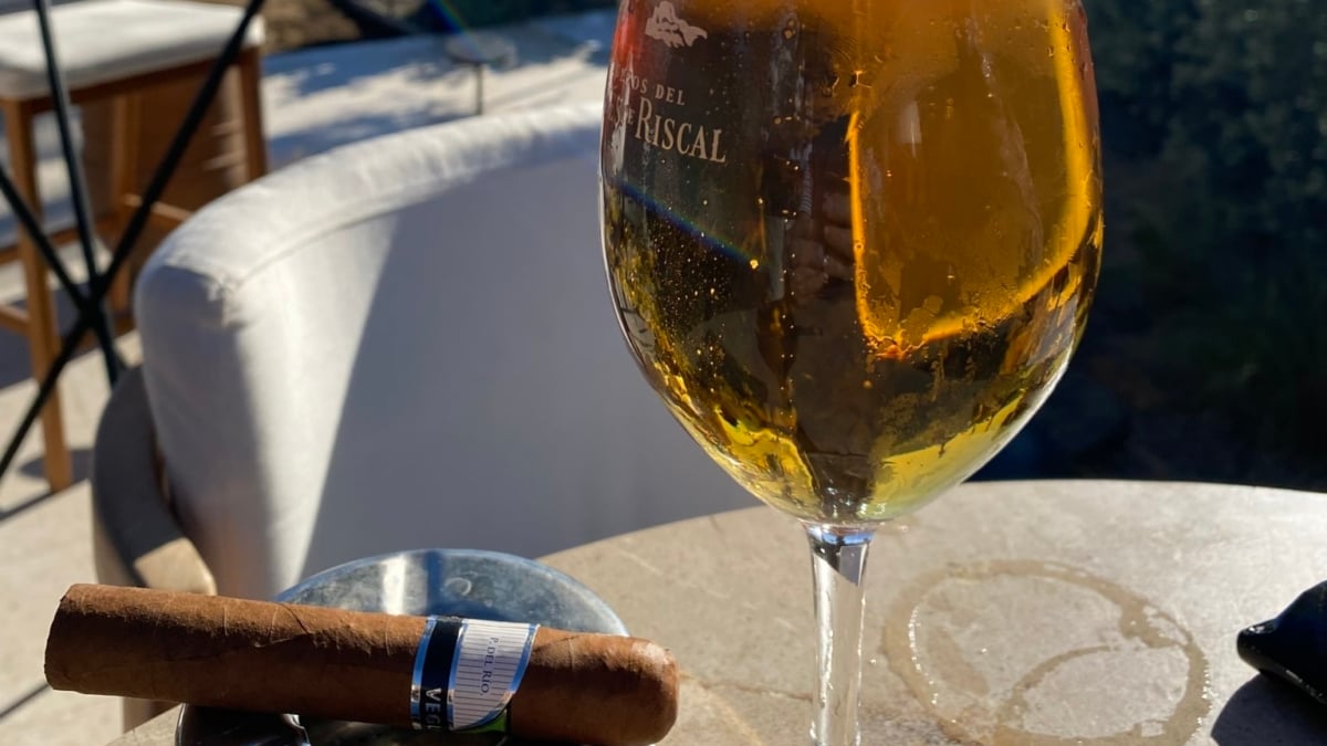 Habano y copa de cerveza en una terraza de la costa.