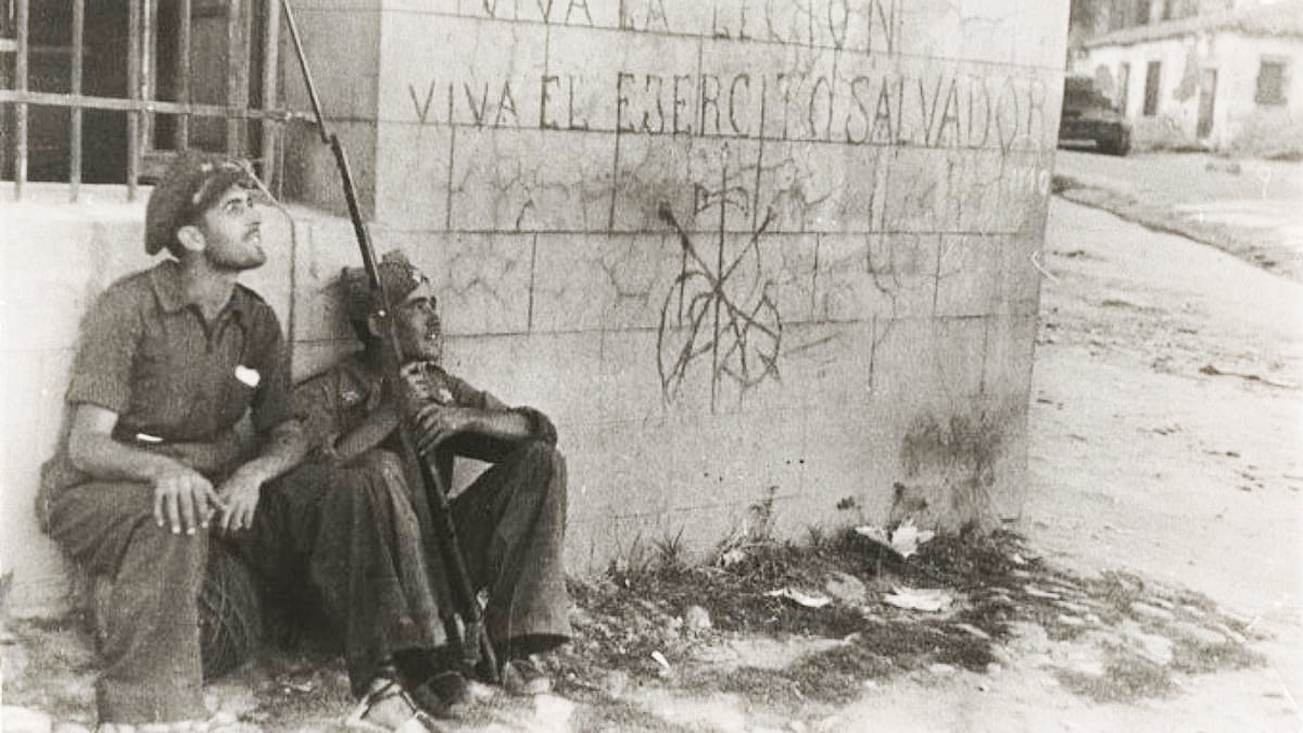 Dos soldados republicanos delante de un muro con lemas y símbolos derechistas en Brunete, en julio de 1937